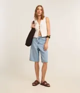 Chaleco blanco sin mangas con lazo delantero.