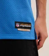Remera deportiva azul con cuello en V y mangas cortas con rayas blancas y doradas. Estampado frontal con el logo de Los Angeles Chargers, el número 60 y la inscripción "est.". Confeccionada con tecnología Dry para mayor transpirabilidad.