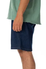 Bermuda de jean azul oscuro, corte recto, largo hasta la rodilla.