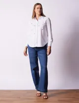 Camisa blanca de algodón con cuello clásico, escote en V y cierre frontal con botones. Presenta apliques de brillos plateados en el frente y mangas largas con puños abotonados.