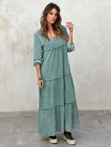 Vestido largo color morado, con escote en V, mangas largas y corte escalonado.