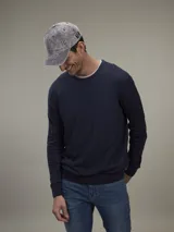 Sweater de punto color beige claro, de corte clásico y cuello redondo.