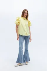 Pantalón de jean acampanado color marrón con alforza central y ruedo desflecado.