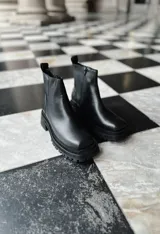 Botas de cuero negro con punta cuadrada, caña media y cierre lateral con cremallera.