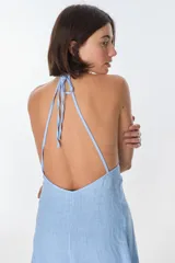 Conjunto de top halter con abertura en el abdomen y falda cruzada con ruedo desflecado, color fucsia.