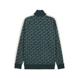 Campera deportiva Puma T7 AOP, color verde con estampado del logo de la marca en blanco. Presenta cierre frontal, cuello alto, bolsillos laterales y mangas largas con franjas blancas.