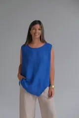 Musculosa azul francia confeccionada en lino italiano, de corte recto, con escote redondo y ruedo asimétrico.