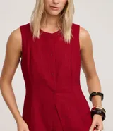 Chaleco rojo con cuello redondo, sin mangas y cierre frontal con botones forrados.