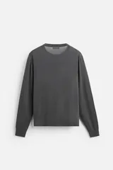 Jersey negro de lana con acabado mercerizado, corte relaxed fit, cuello redondo y manga larga con terminaciones en rib.