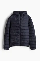 Campera puffer liviana en tejido guateado color azul marino. Modelo con capucha, cierre con protección para el mentón y bolsillos con cierre oculto en las costuras laterales. Ribete de cinta elástico en los puños. Corte ajustado que realza el contorno del cuerpo creando una silueta entallada. Sin forrar.