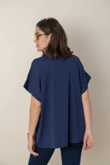 Remera holgada color beige, de escote en V y mangas cortas.