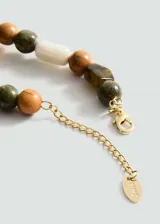 Collar corto con cuentas de diferentes formas y colores: marrón, verde, beige y naranja. Cierre de mosquetón con cadena de alargue dorada.