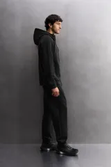 Sudadera con capucha color marrón topo, de corte regular fit, confeccionada en tejido técnico compacto de algodón con elasticidad. Cuenta con cuello subido, manga larga con bolsillo, bolsillos frontales con cierre de cremallera y acabados con rib del mismo tejido.