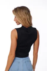 Top negro sin mangas con cuello alto y textura acanalada.