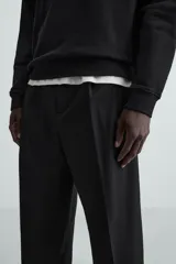 Pantalón de vestir color beige, corte wide fit, con cintura elástica, pliegues frontales, bolsillos laterales y traseros de vivo.