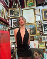 Top negro con escote halter profundo y detalle de tachas plateadas.