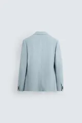 Blazer slim fit color celeste confeccionada en tejido con viscosa. Cuello con solapas de muesca. Manga larga acabada en puño con detalle de botones. Bolsillo de vivo en pecho y de solapa en cadera. Detalle bolsillo interior. Bajo con aberturas en espalda. Cierre frontal con botones.