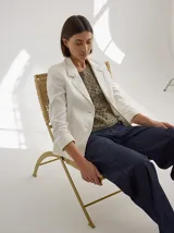 Blazer color mostaza de lino con corte estructurado, solapas con pespuntes y bolsillos con solapa.