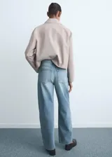 Jeans de mujer color celeste claro, tiro alto, estilo barrel/balloon con pierna ancha y caída recta. Presenta cinco bolsillos y cierre frontal con botón y cremallera.