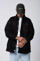 Camisa verde militar de manga larga, corte oversize, con cuello clásico, cierre frontal con botones y bolsillo en el pecho. Confeccionada en algodón suave y con costuras a la vista.