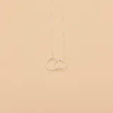 Gargantilla de plata 925 con dije de dos aros entrelazados, uno liso y otro texturizado.