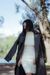 Vestido color crudo, con cuello alto y mangas cortas, confeccionado en tejido elastizado que se adapta a la silueta.