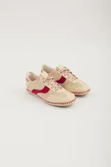 Championes de cuero color beige con detalles en rojo, suela de yute y cordones con diseño trenzado.