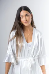 Bata corta color blanco de satén elastizado, con mangas tres cuartos con volados y lazo para atar en la cintura.
