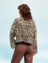 Campera color marrón claro con cuello solapa, cierre frontal con botones y bolsillos con solapa en el pecho.