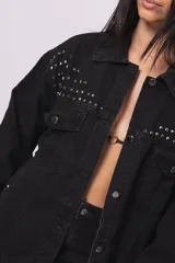 Campera de jean negra con tachas plateadas en cuello, hombros y mangas.