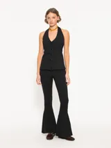 Pantalón negro acampanado confeccionado en j-tecno e fit flare, con cintura elástica, cierre lateral, recortes en el delantero y ruedo con godets que aportan amplitud.