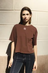 Remera negra de algodón con corte cuadrado, cuello redondo y logo bordado en color naranja.