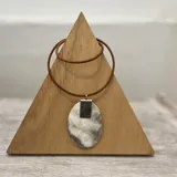 Colgante de cuero con diseño ovalado en guampa, ideal para complementar cualquier outfit.