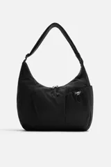 Bolso negro de tela técnica con correa de hombro ajustable. Tiene un compartimento principal con cierre de cremallera, un bolsillo interior con cremallera y tres bolsillos exteriores, uno de ellos con cremallera.