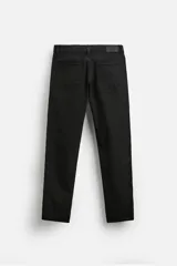 Pantalón de jean azul oscuro, corte slim fit, tiro medio, cinco bolsillos, tejido elástico y efecto lavado.