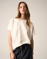 Remera color crema de corte holgado con mangas cortas y cuello redondo.