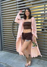 Maxi camisa color rosa con volados en el ruedo y mangas largas acampanadas.