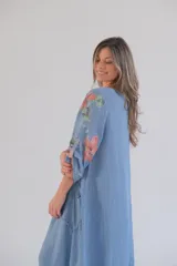 Vestido largo celeste con estampado de flores color salmón, corte holgado, mangas 3/4 con ajuste en los puños y ruedo irregular con terminación desflecada.
