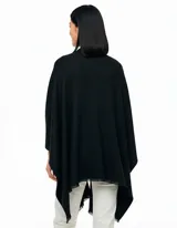 Ruana de tejido soft color beige, con cuello en V y un lazo o pasador frontal para ajustar. El ruedo tiene terminación desflecada.