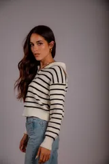 Sweater de punto color beige con rayas horizontales blancas, cuello polo con cierre de cremallera y mangas largas.
