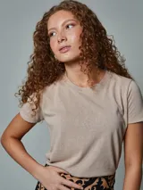 Remera color beige de corte clásico y mangas cortas. Confeccionada en tejido slub de algodón y poliéster.