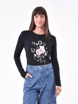 Remera verde militar de manga larga con cuello en V y estampado floral en tonos naranja.
