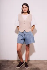 Chaleco de punto color beige con cuello en V y cierre frontal con botones.