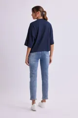 Remera de manga tres cuartos, color azul marino, con cuello alto tipo mock neck y corte holgado.