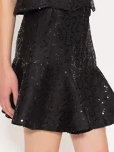 Minifalda negra con lentejuelas y volados en el ruedo.