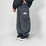 Pantalón jean negro de corte ultra baggy, con bolsillos cargo laterales y logo estampado en el muslo.