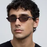 Lentes de sol ovalados con montura fina color marrón y lentes marrones polarizadas.