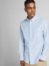 Camisa de vestir a rayas verticales celestes y blancas, de manga larga y cuello abotonado. Cierre con botones y corte slim fit.
