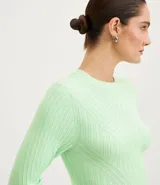 Blusa de punto color verde agua, con cuello redondo y manga larga.