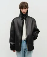 Chaqueta negra de cuero vegano con forro de sherpa, solapas con hebillas, cuello italiano, cierre de cremallera y mangas con puños.